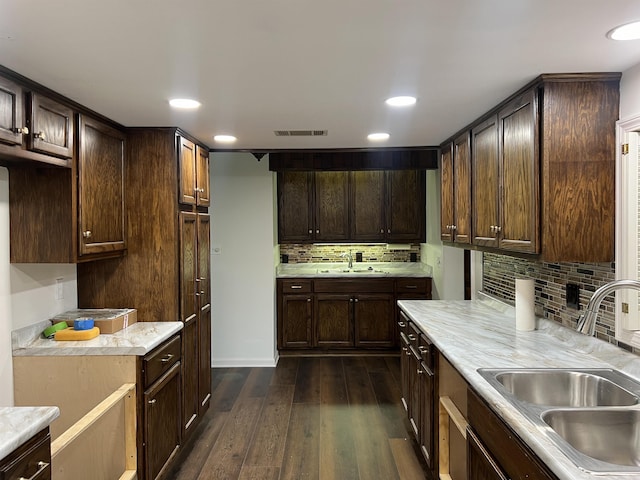 kitchen with sink, dark brown cabinets, and dark wood-type flooring