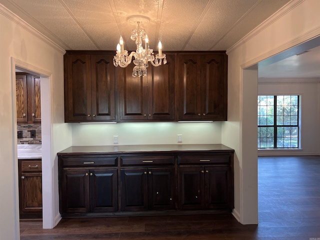 kitchen with crown molding, dark brown cabinets, and dark hardwood / wood-style floors