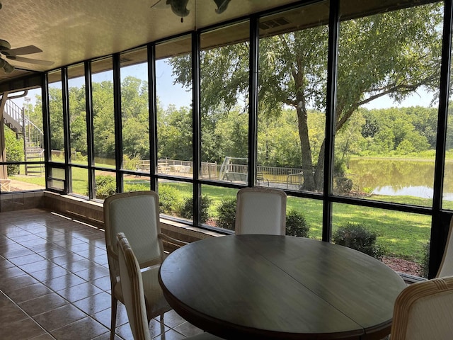 sunroom / solarium featuring a water view and ceiling fan