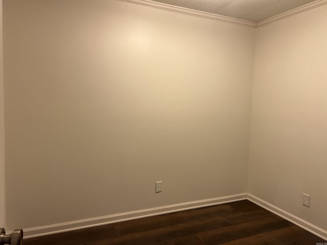 unfurnished room featuring dark wood-type flooring and ornamental molding