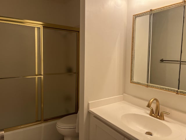 full bathroom featuring enclosed tub / shower combo, vanity, and toilet