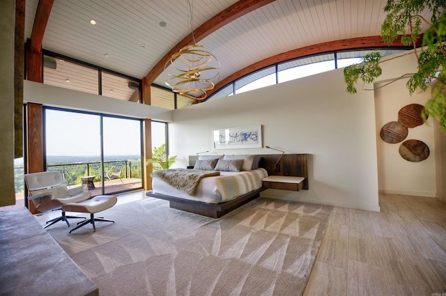 bedroom featuring beam ceiling, access to exterior, wooden ceiling, and a high ceiling