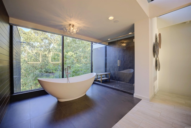 bathroom featuring expansive windows and shower with separate bathtub