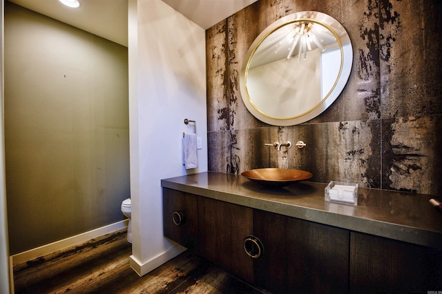 bathroom with hardwood / wood-style flooring, vanity, and toilet