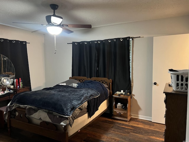 bedroom with dark wood-style floors, a textured ceiling, baseboards, and a ceiling fan