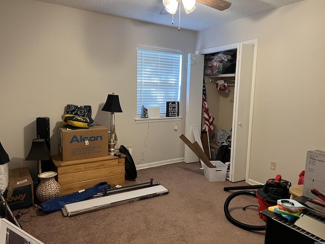 workout area featuring ceiling fan, baseboards, a textured ceiling, and carpet flooring