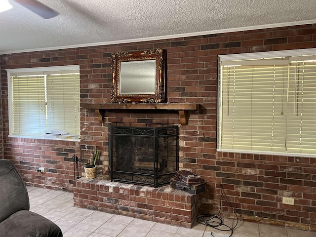 living area with a fireplace, a textured ceiling, brick wall, and light tile patterned floors