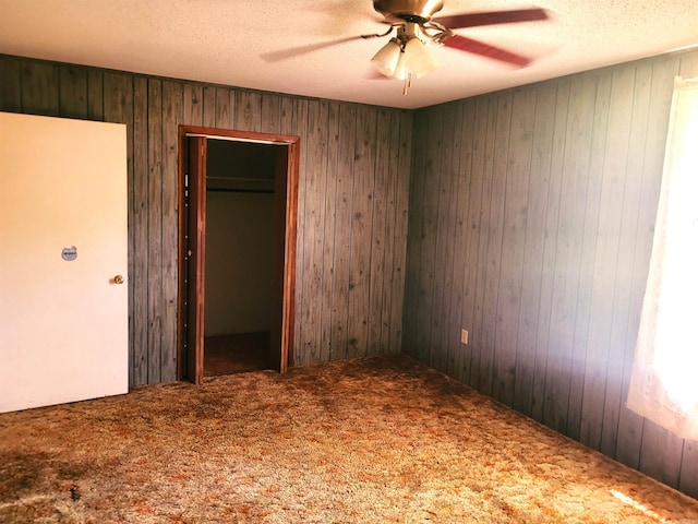 unfurnished bedroom featuring a closet, carpet floors, a textured ceiling, and ceiling fan