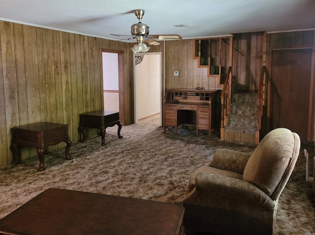 carpeted living room featuring a textured ceiling, ceiling fan, and wooden walls