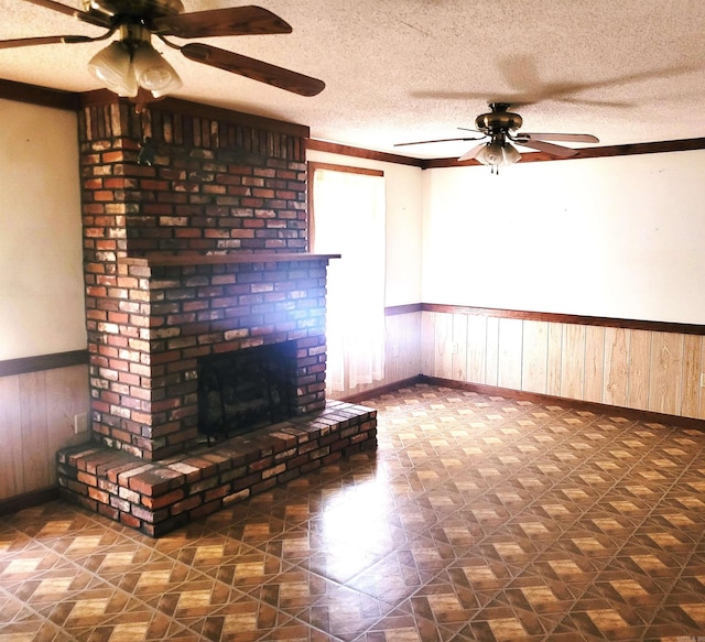 unfurnished living room with brick wall, a fireplace, a textured ceiling, and ceiling fan