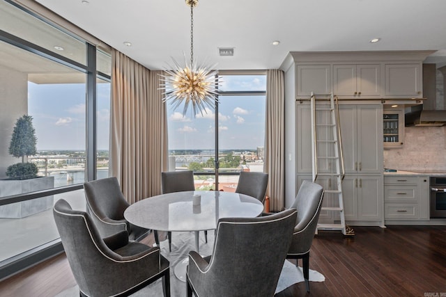 dining area with dark hardwood / wood-style floors, a healthy amount of sunlight, and a chandelier