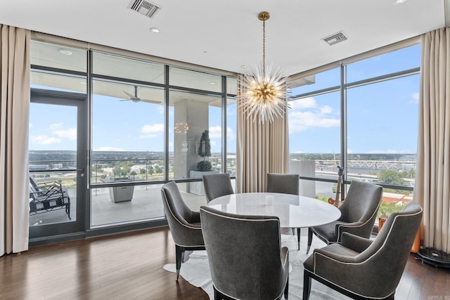 dining room featuring a notable chandelier, expansive windows, and hardwood / wood-style floors