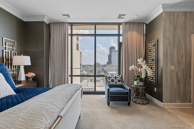 bedroom with ornamental molding and a wall of windows