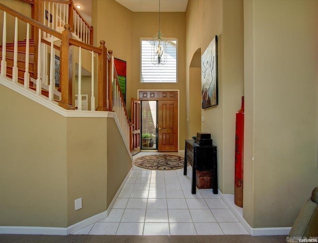 foyer entrance featuring a towering ceiling and light tile patterned floors