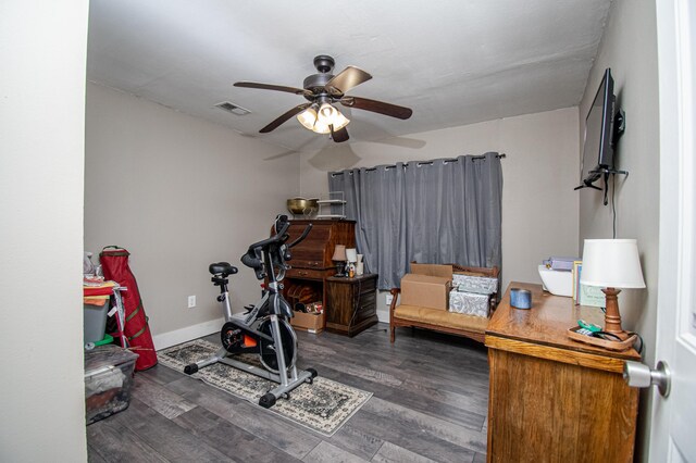 exercise room featuring ceiling fan and dark hardwood / wood-style floors