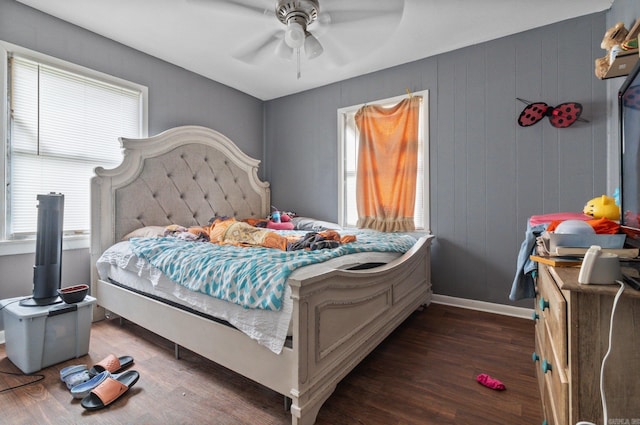 bedroom with wood finished floors, multiple windows, and baseboards
