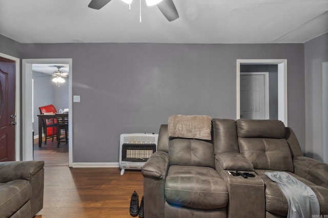 living room with ceiling fan, heating unit, wood finished floors, and baseboards