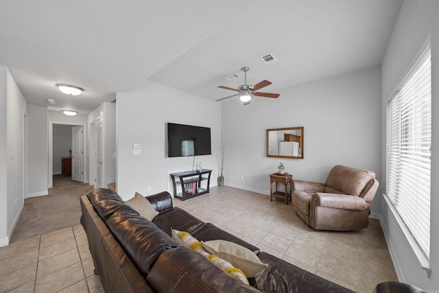 living room featuring ceiling fan, light tile patterned flooring, visible vents, and baseboards