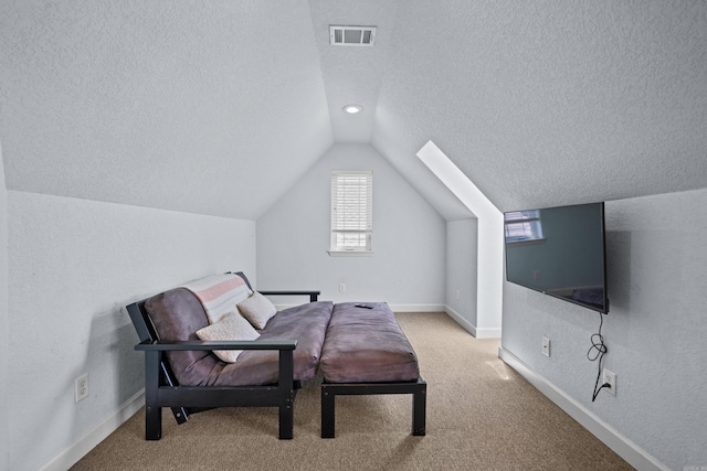 carpeted bedroom with a textured ceiling, lofted ceiling, visible vents, and baseboards