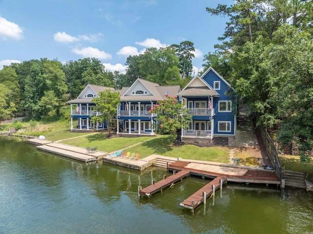 rear view of property featuring a yard, a water view, and a balcony