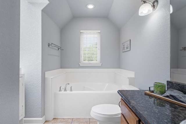 bathroom with toilet, vanity, vaulted ceiling, a bath, and tile patterned floors