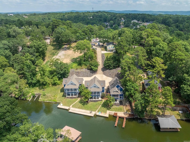 birds eye view of property with a water view and a wooded view