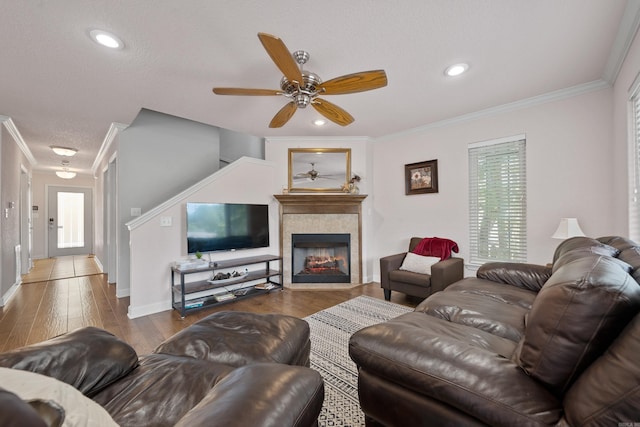 living room with hardwood / wood-style flooring, baseboards, ornamental molding, and a fireplace with flush hearth