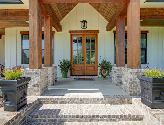 view of exterior entry with covered porch and french doors