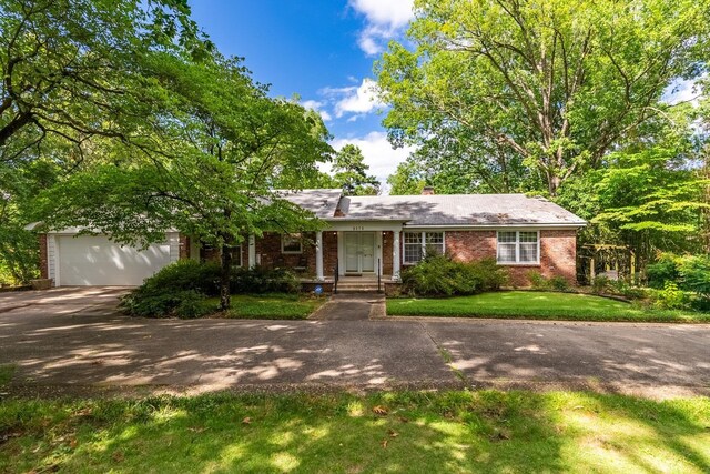 single story home featuring a garage and a front yard