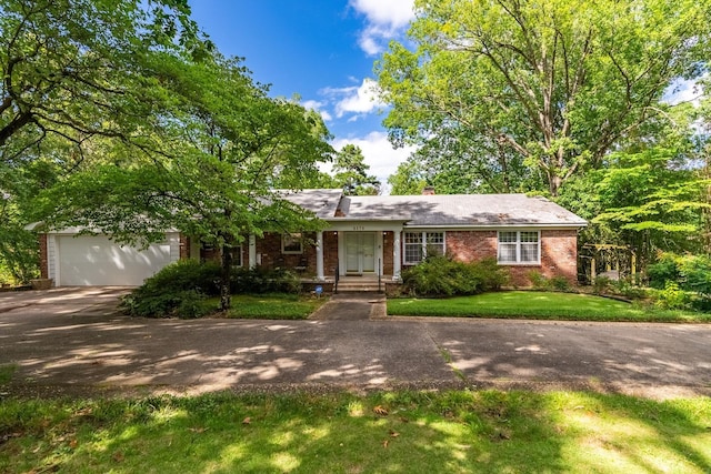 ranch-style house with a garage and a front lawn