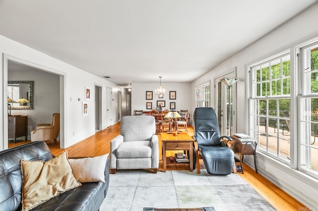 living room featuring an inviting chandelier and light wood-type flooring