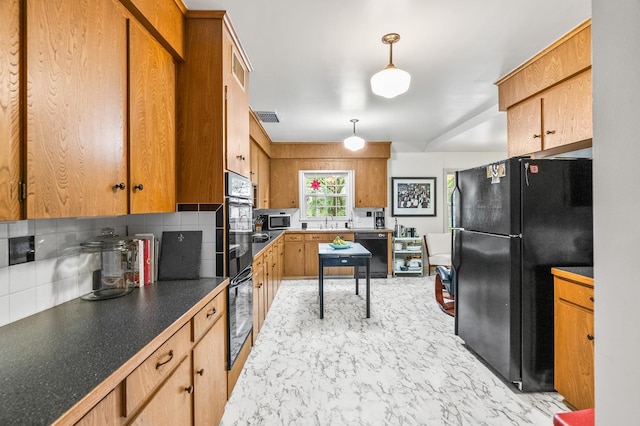 kitchen with hanging light fixtures, sink, backsplash, and black appliances