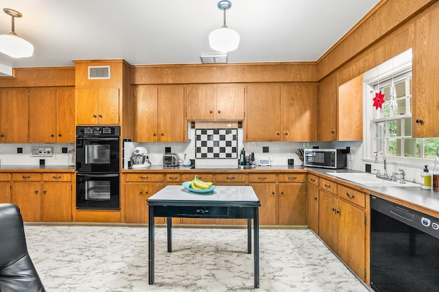 kitchen with pendant lighting, sink, tasteful backsplash, and black appliances