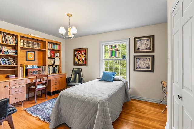 bedroom featuring a notable chandelier, light wood-type flooring, and a closet