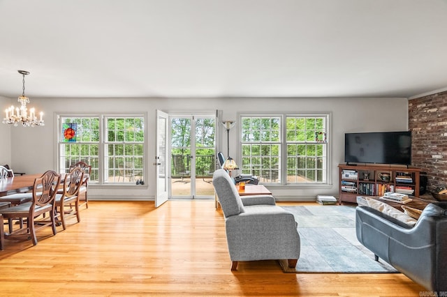 living room with an inviting chandelier and light hardwood / wood-style flooring