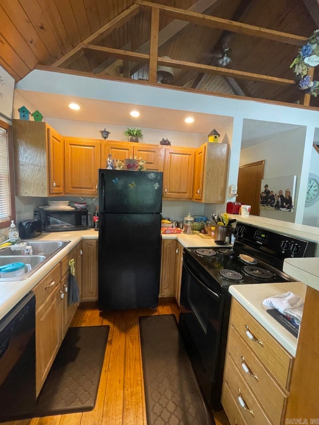 kitchen with black appliances, vaulted ceiling, wood ceiling, sink, and light hardwood / wood-style floors