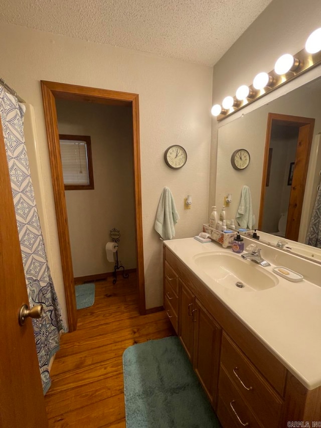 bathroom with vanity, a textured ceiling, and hardwood / wood-style flooring