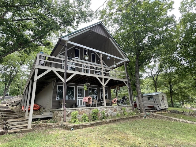 509A Woodland Hills Rd, Hardy, AR 72542 - back of property featuring stairs, a wooden deck, a lawn, and an outbuilding