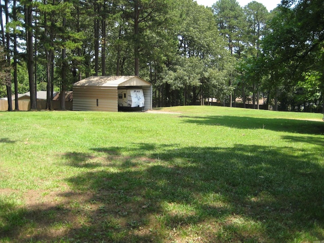 view of yard featuring a garage and an outbuilding