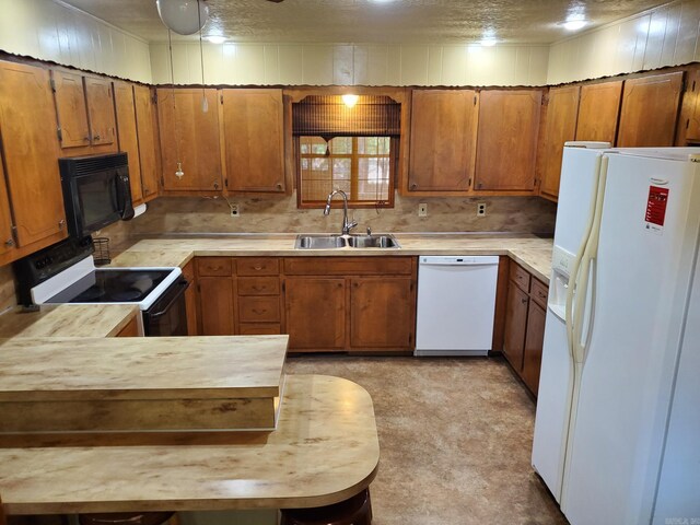 901 Hastey Ave, Mena, AR 71953 - kitchen featuring light countertops, brown cabinets, a peninsula, white appliances, and a sink