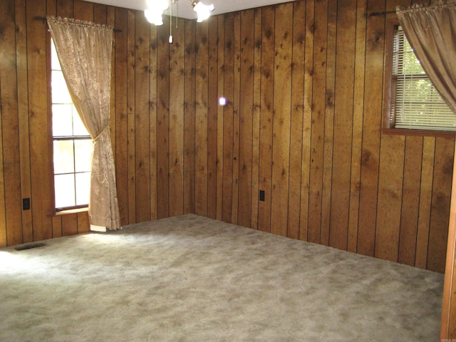 901 Hastey Ave, Mena, AR 71953 - spare room featuring wooden walls, carpet, visible vents, and ceiling fan