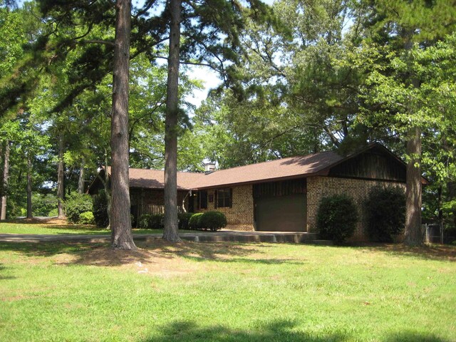 901 Hastey Ave, Mena, AR 71953 - ranch-style home with brick siding, a front lawn, and a garage
