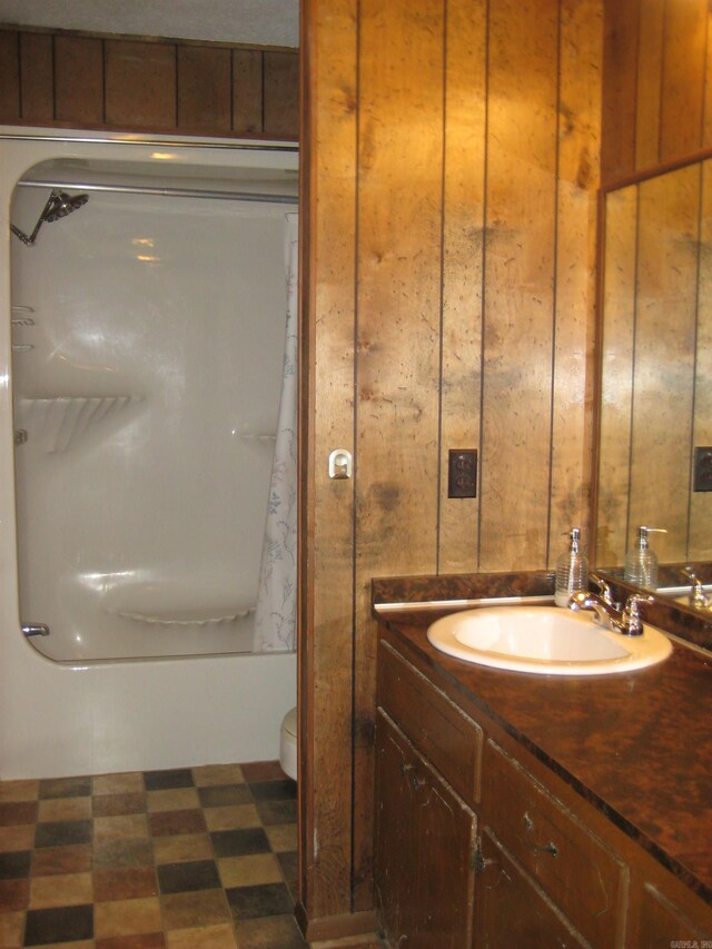 901 Hastey Ave, Mena, AR 71953 - bathroom with tile patterned floors, toilet, wood walls, and vanity