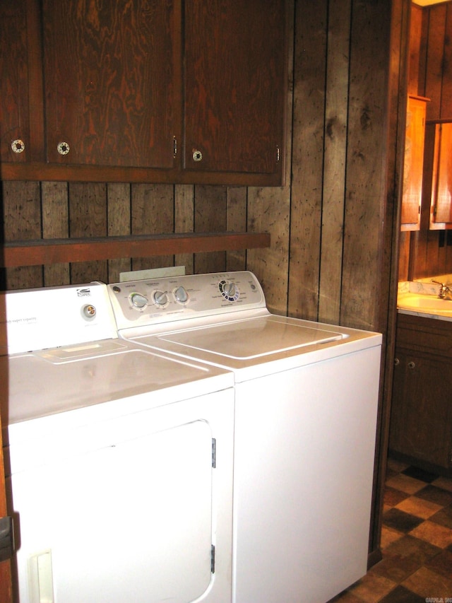 901 Hastey Ave, Mena, AR 71953 - clothes washing area featuring tile patterned floors, independent washer and dryer, a sink, cabinet space, and wooden walls