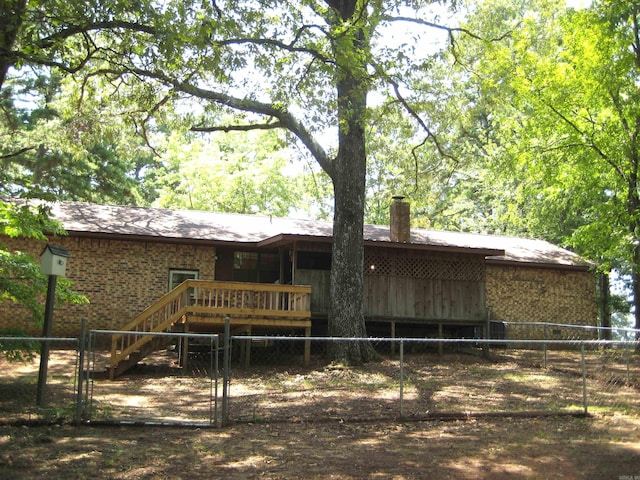 901 Hastey Ave, Mena, AR 71953 - rear view of property featuring brick siding, fence, stairs, a chimney, and a gate