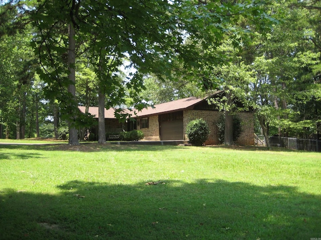 901 Hastey Ave, Mena, AR 71953 - view of yard featuring an attached garage and fence