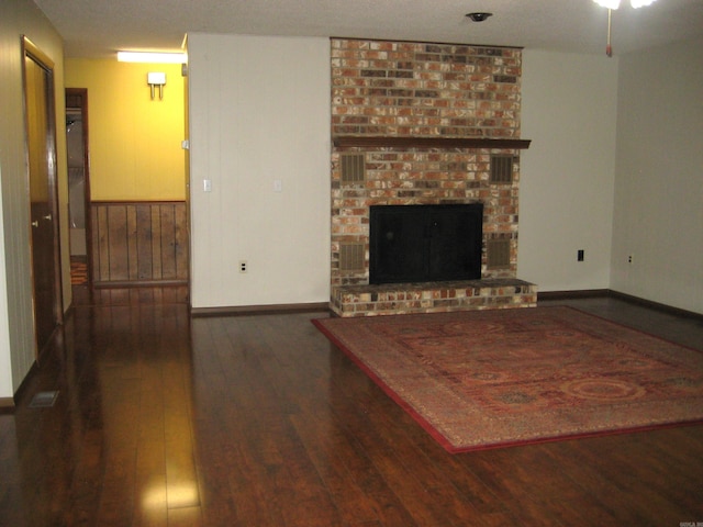 901 Hastey Ave, Mena, AR 71953 - unfurnished living room featuring a fireplace, wood finished floors, and baseboards