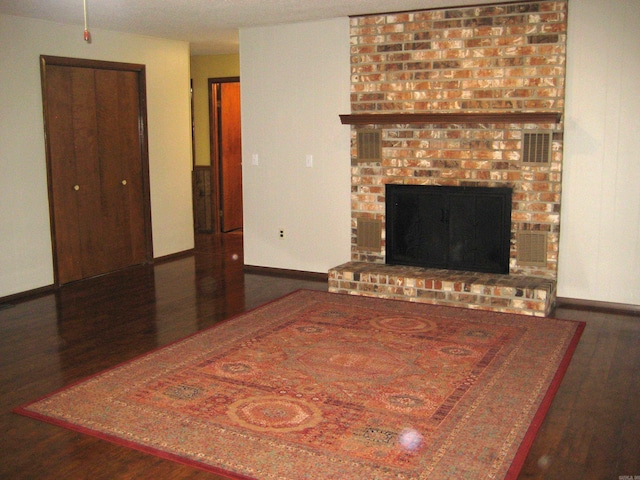 901 Hastey Ave, Mena, AR 71953 - living area featuring visible vents, a fireplace, baseboards, and wood finished floors