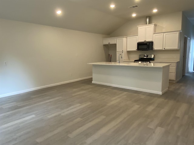 kitchen featuring white cabinetry, hardwood / wood-style floors, a kitchen island with sink, and stainless steel electric range