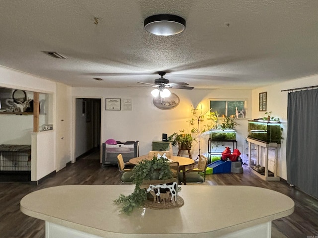 dining area featuring dark hardwood / wood-style flooring, a textured ceiling, and ceiling fan